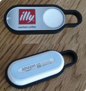 The Dash Button comes with a removable plastic loop for hanging on a key chain or a hook. The back has adhesive for sticking. Visible on the front of the device is the port for the microphone, used for receiving ultrasonic signals during setup with an iPhone.